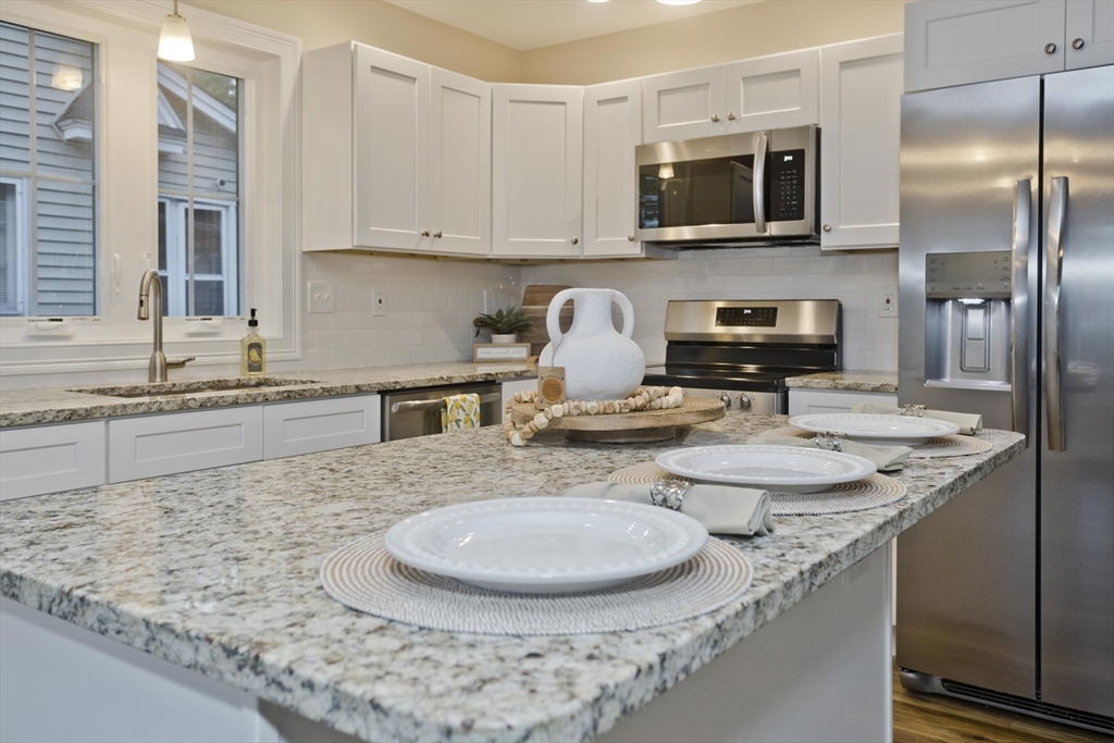 a kitchen with stainless steel appliances granite countertop a sink a stove and a microwave