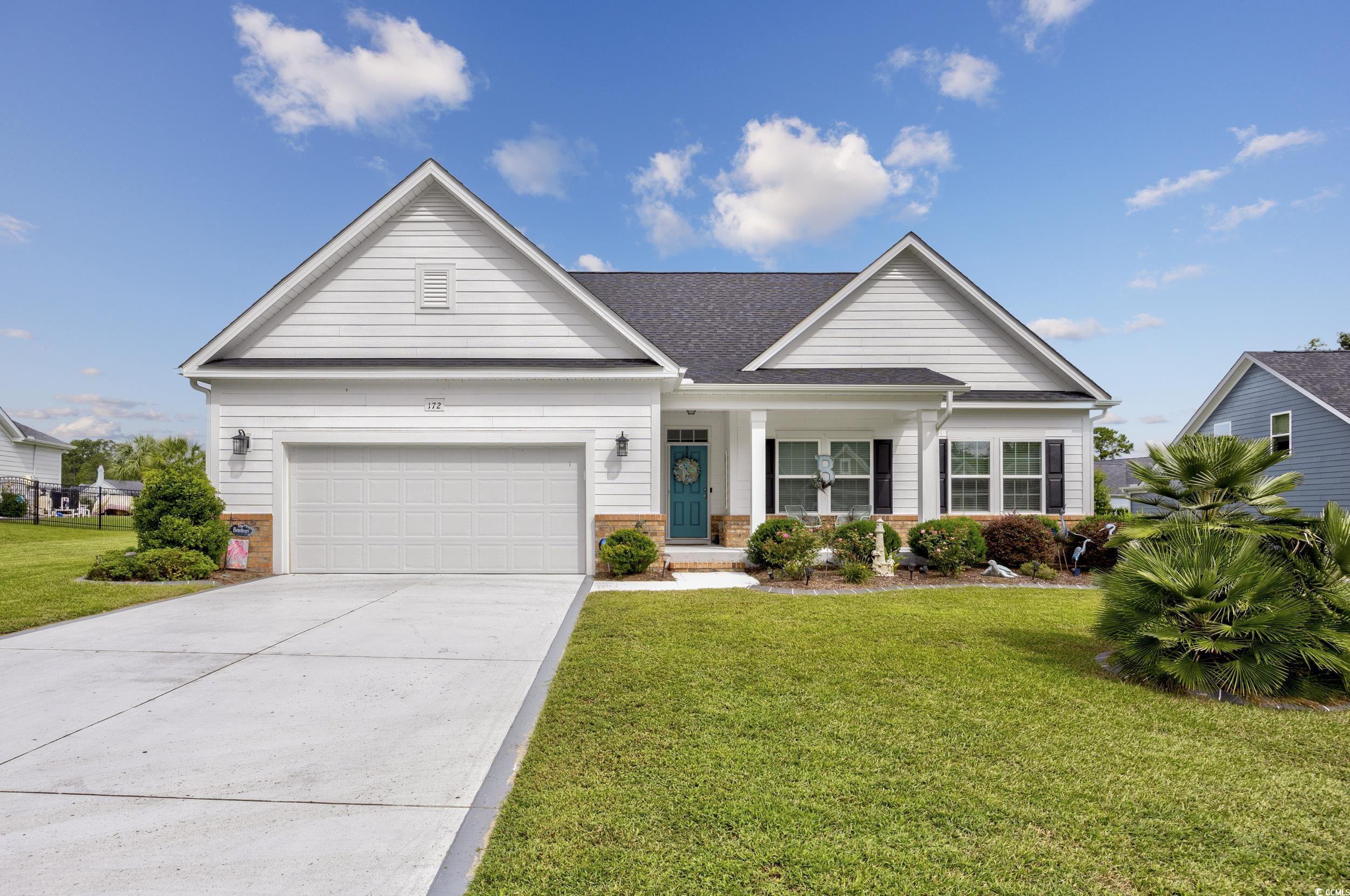 View of front of house featuring a garage, a porch