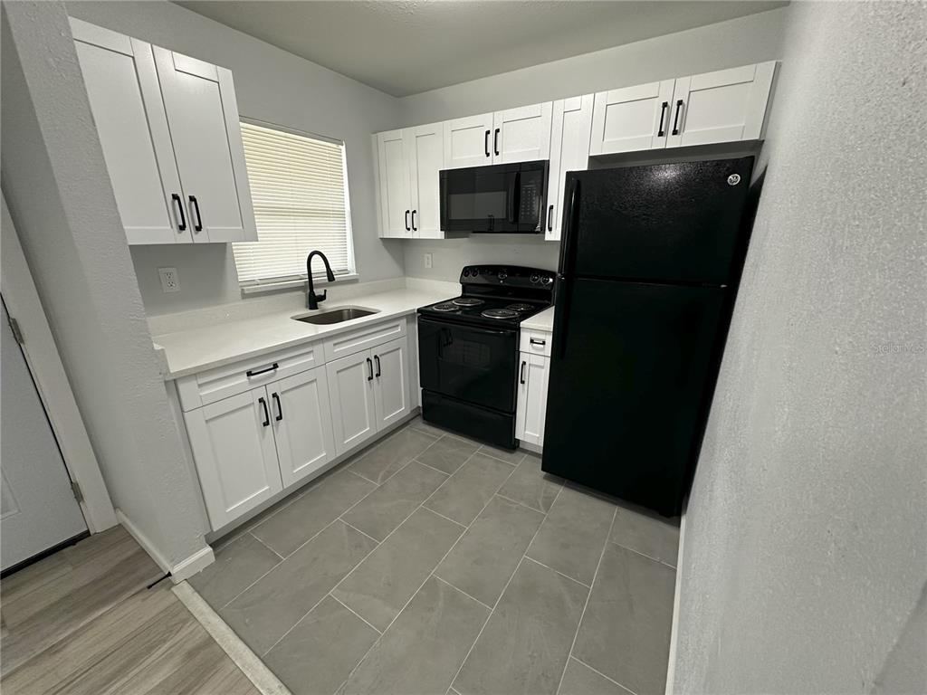 a kitchen with a sink stainless steel appliances and cabinets