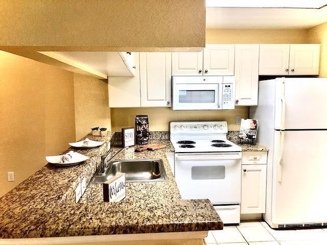 a kitchen with a stove a refrigerator and a sink