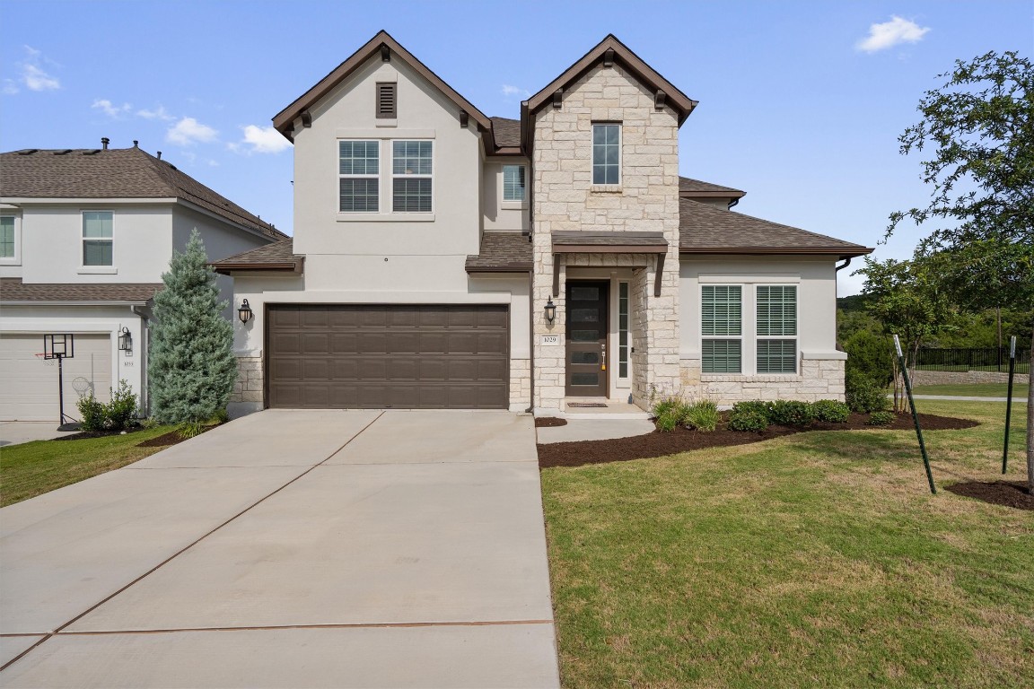 a front view of a house with a yard and garage