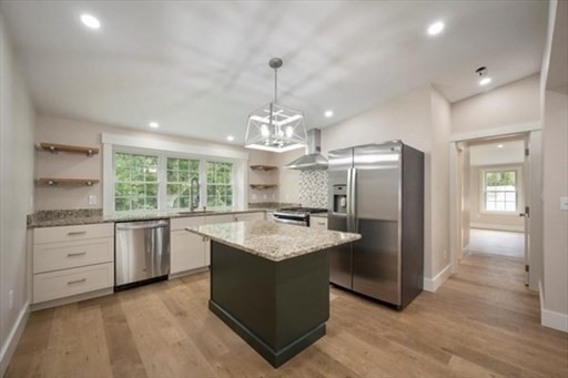 a kitchen with kitchen island granite countertop a stove oven and refrigerator