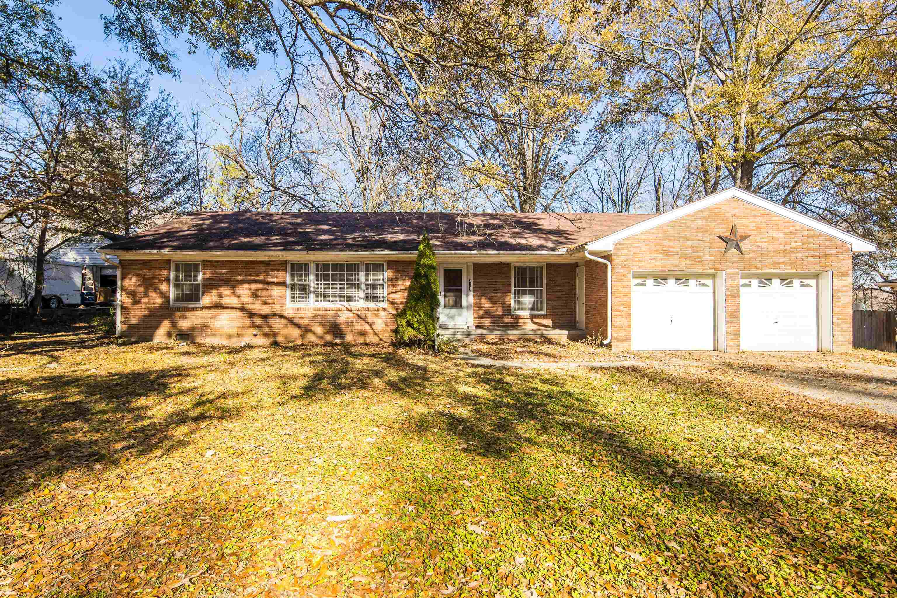 Single story home featuring a front yard and a garage