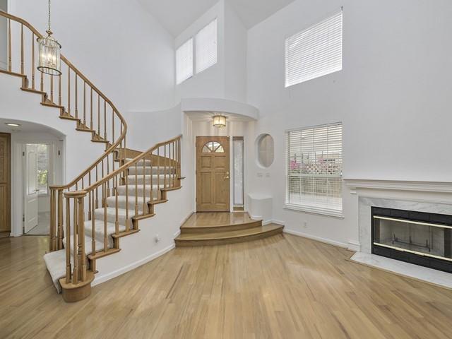 a view of an empty room with wooden floor and a fireplace