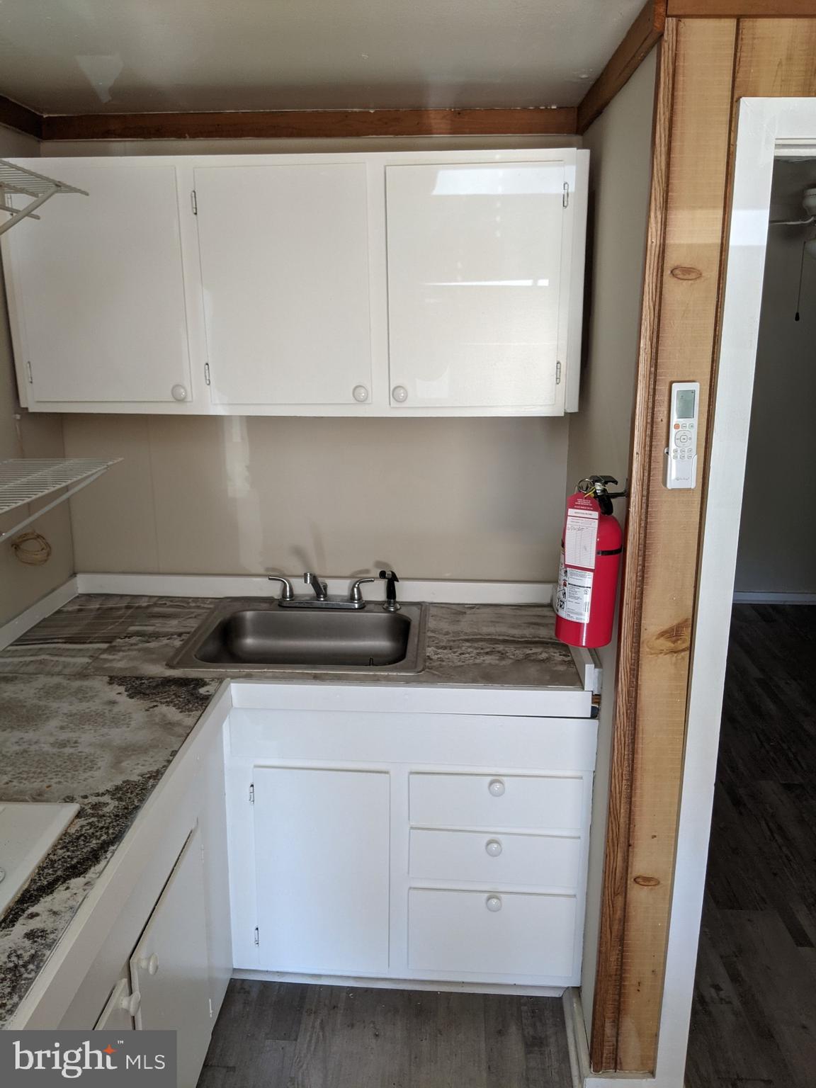 a kitchen with white cabinets and sink