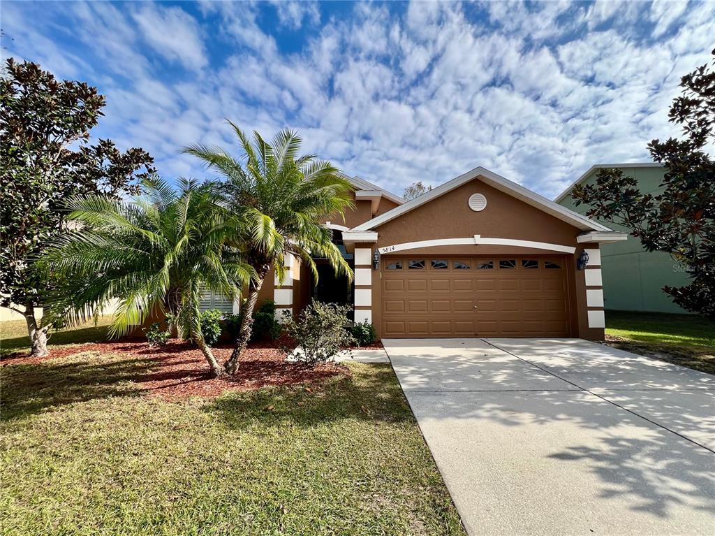 a front view of a house with a yard and garage