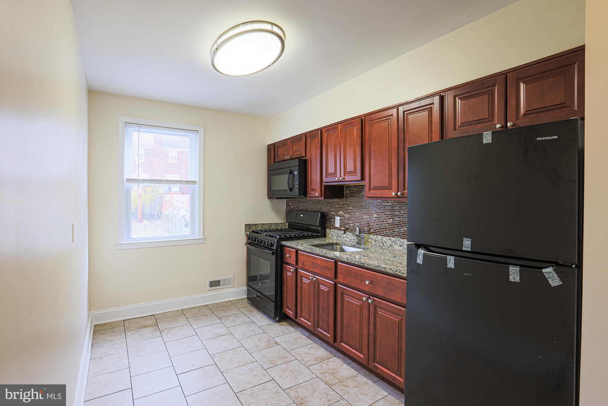 a kitchen with a refrigerator a sink and cabinets