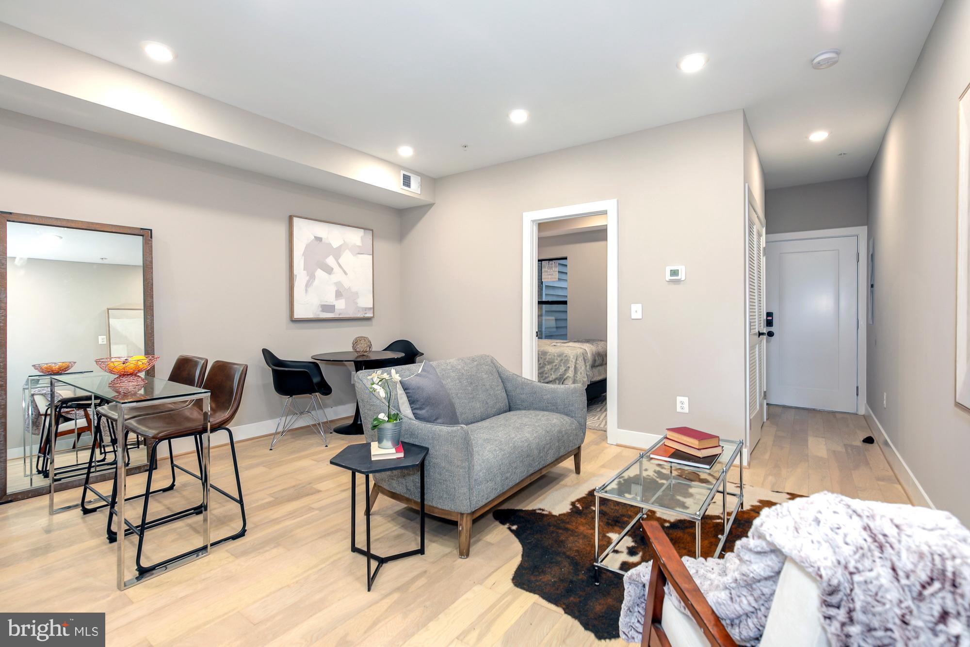 a living room with furniture and wooden floor