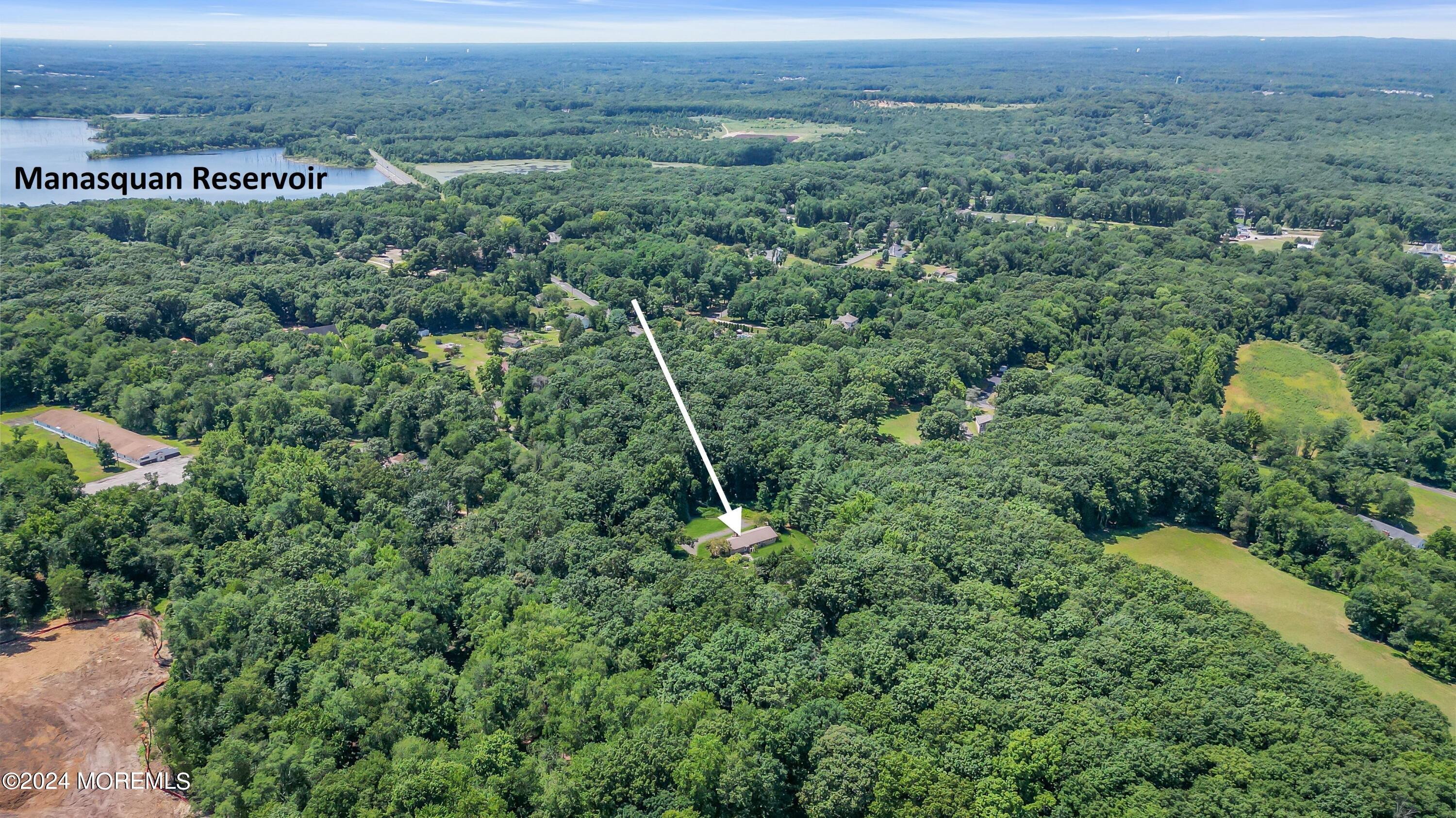 an aerial view of residential houses with outdoor space and trees