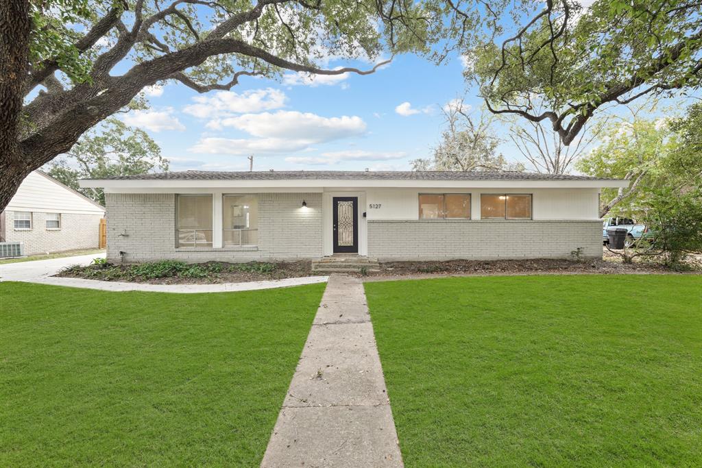 a front view of house with yard and green space