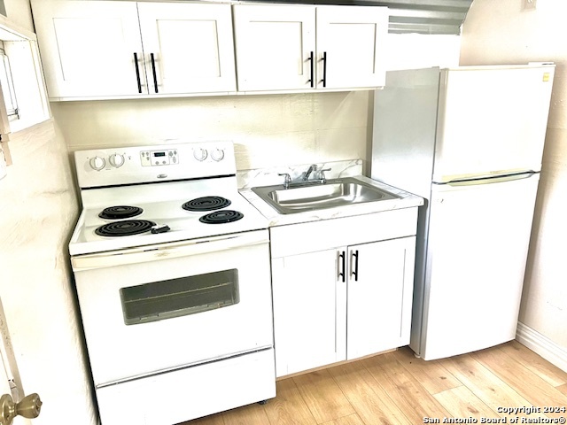 a kitchen with a stove a refrigerator and a sink