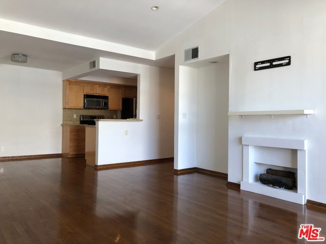 a view of a livingroom with wooden floor and a fireplace