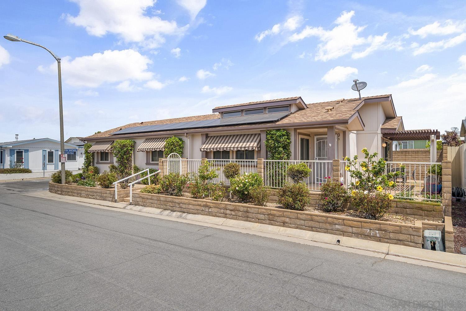 a front view of a house with a garden and balcony