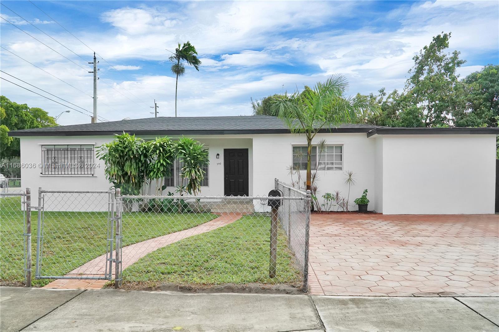 a front view of a house with a yard and potted plants