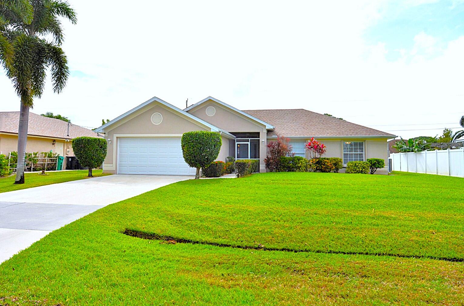 a front view of a house with a garden and yard