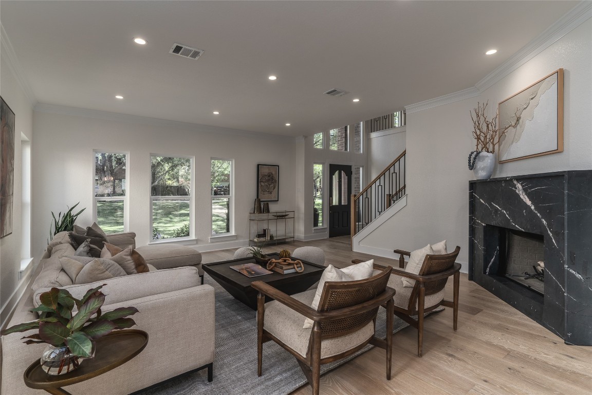 a living room with furniture a fireplace and a large window