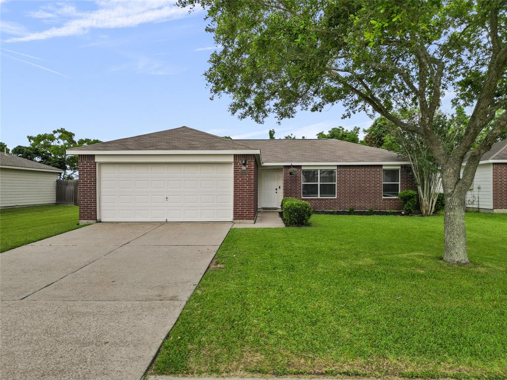 a front view of a house with a yard and trees