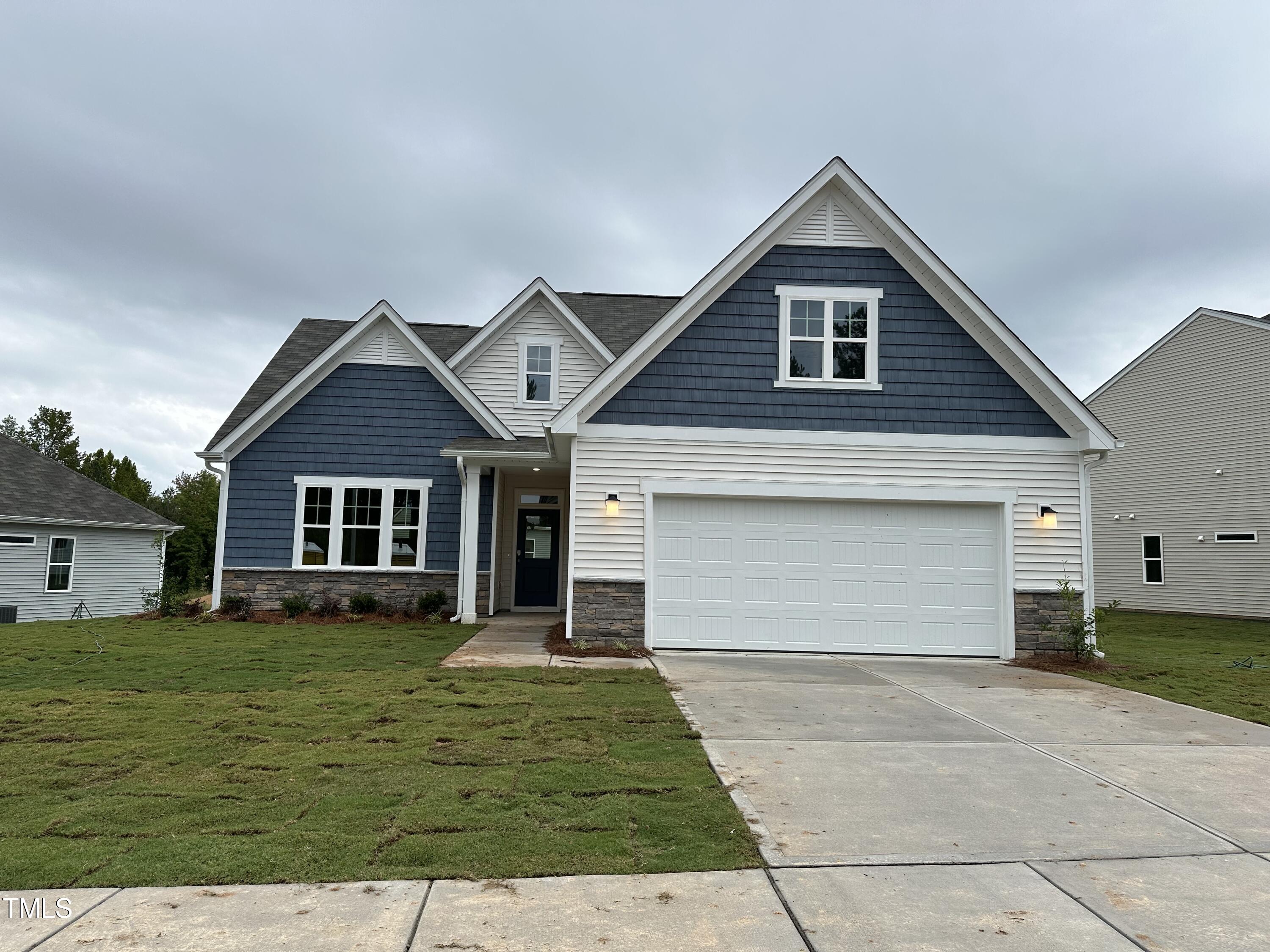 a front view of house with yard and garage