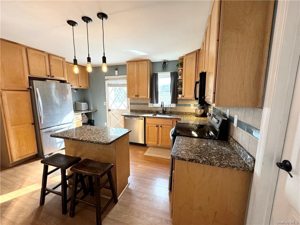 a kitchen with stainless steel appliances granite countertop sink stove and refrigerator