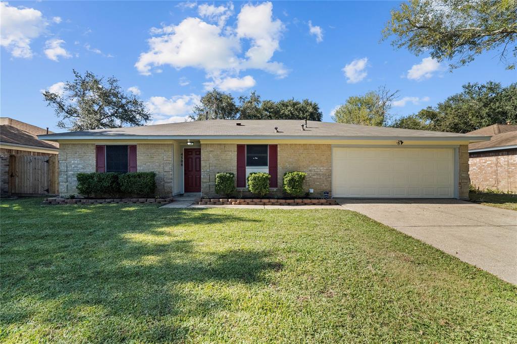 This charming single-story home features a brick exterior with a well-maintained front lawn. It includes a two-car garage and offers a welcoming entrance with red accents around the windows and door.