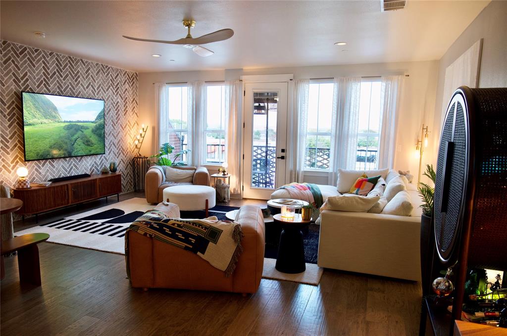 a living room with furniture floor to ceiling window and a flat screen tv