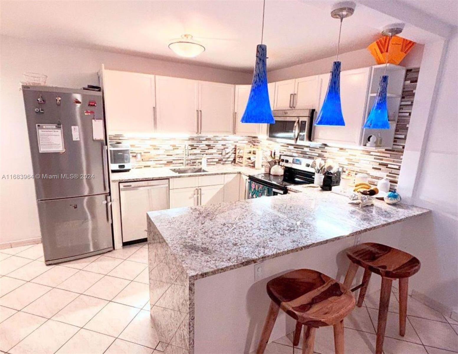 a kitchen with stainless steel appliances granite countertop a sink and a refrigerator