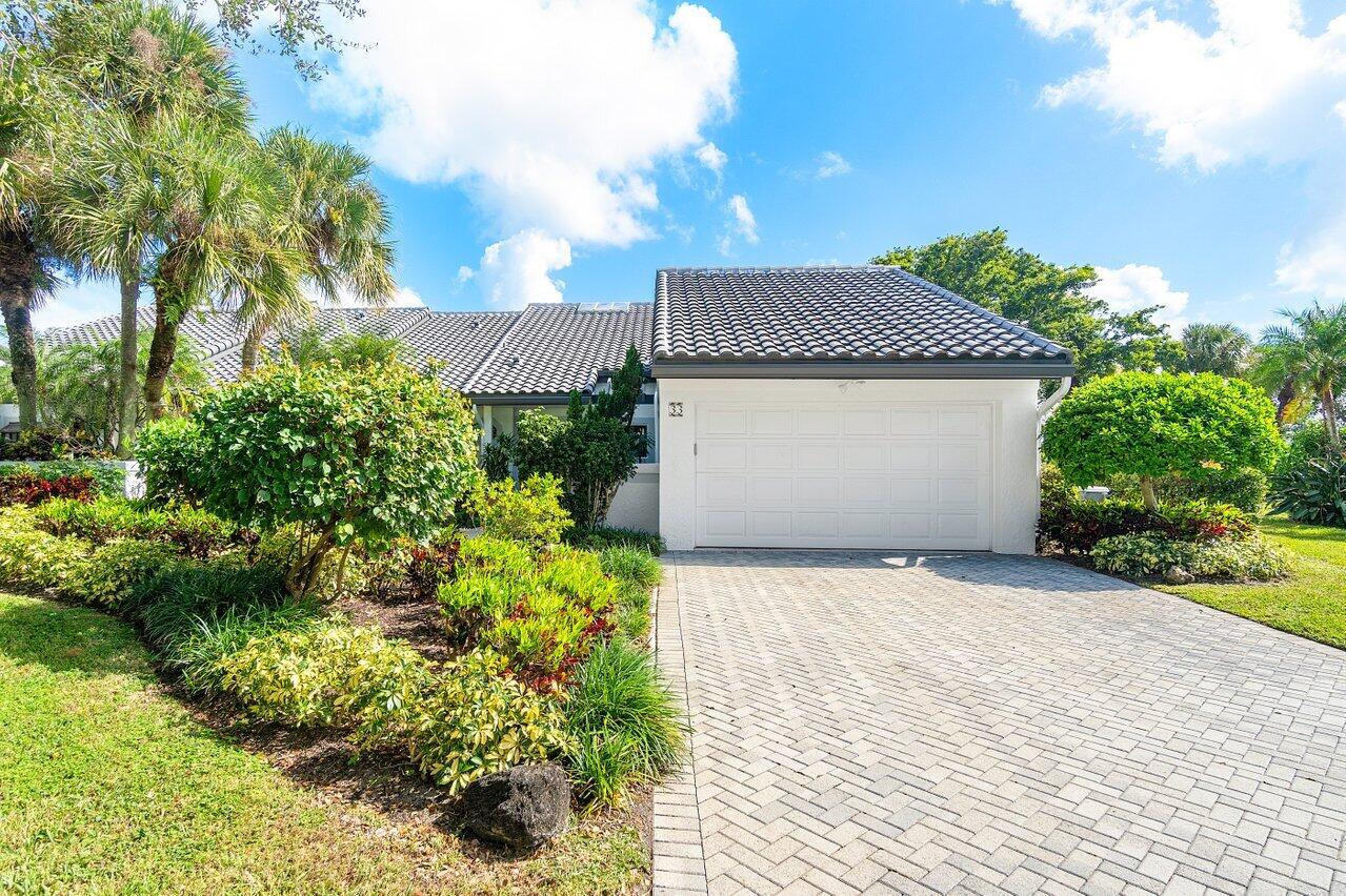 a front view of a house with a yard and covered with plants