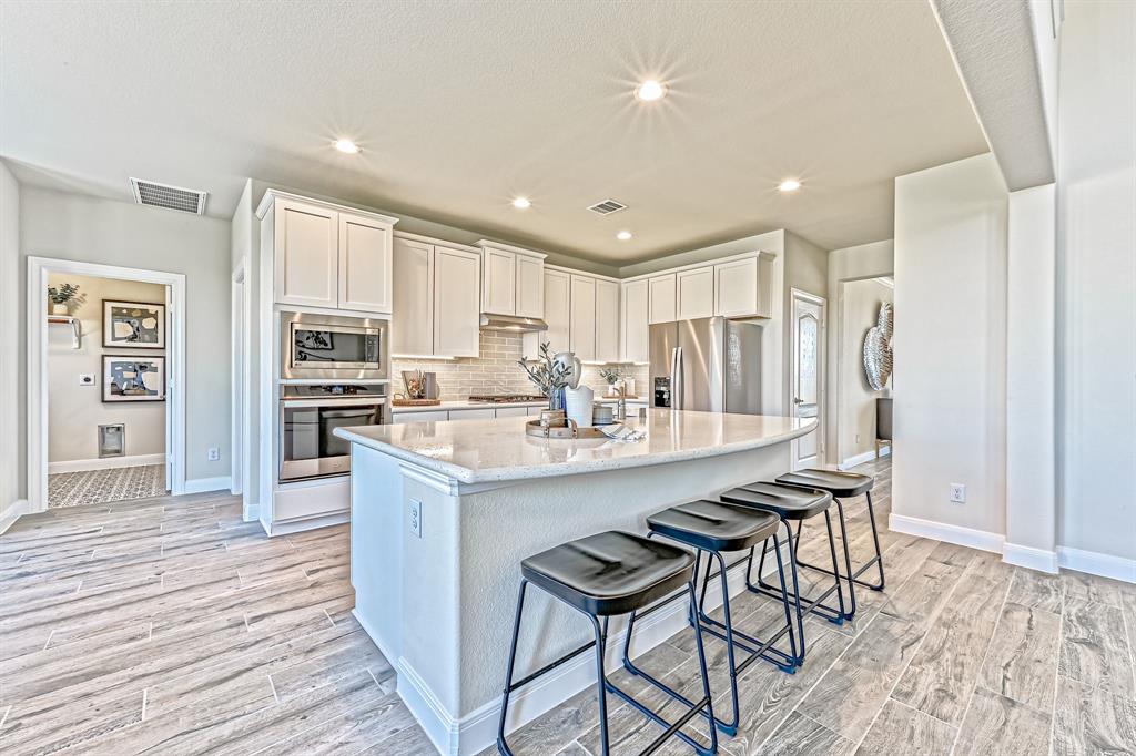 a kitchen with stainless steel appliances kitchen island granite countertop a refrigerator and a stove top oven