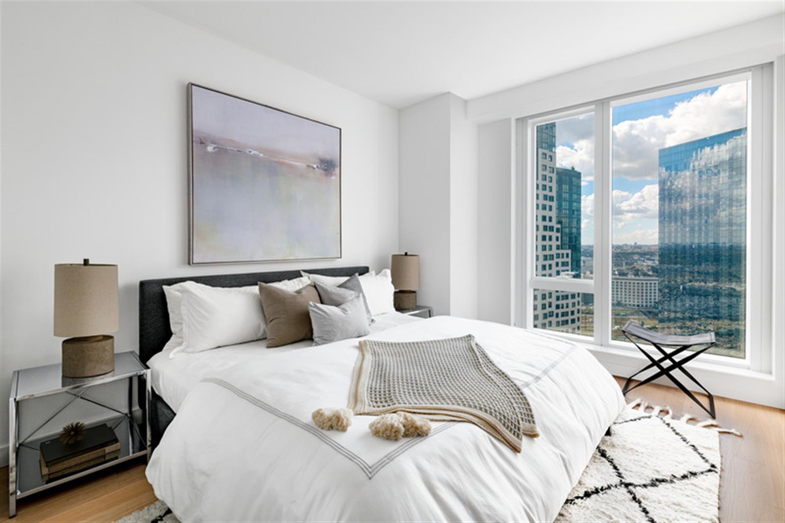 a bedroom with a large bed and a lamp next to a window