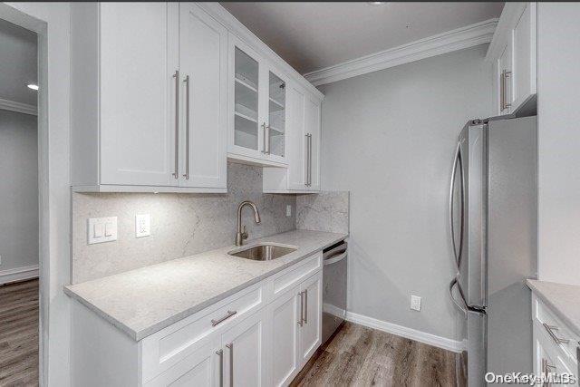 a kitchen with stainless steel appliances granite countertop a refrigerator sink and white cabinets