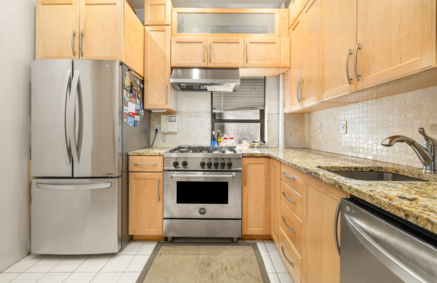 a kitchen with stainless steel appliances granite countertop a refrigerator sink and stove