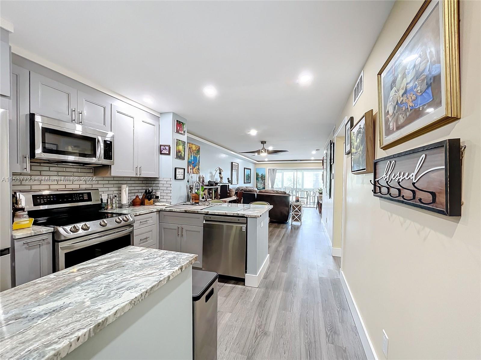 a kitchen with a refrigerator a stove top oven a sink dishwasher and wooden cabinets