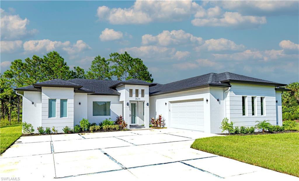 a front view of a house with a yard and potted plants