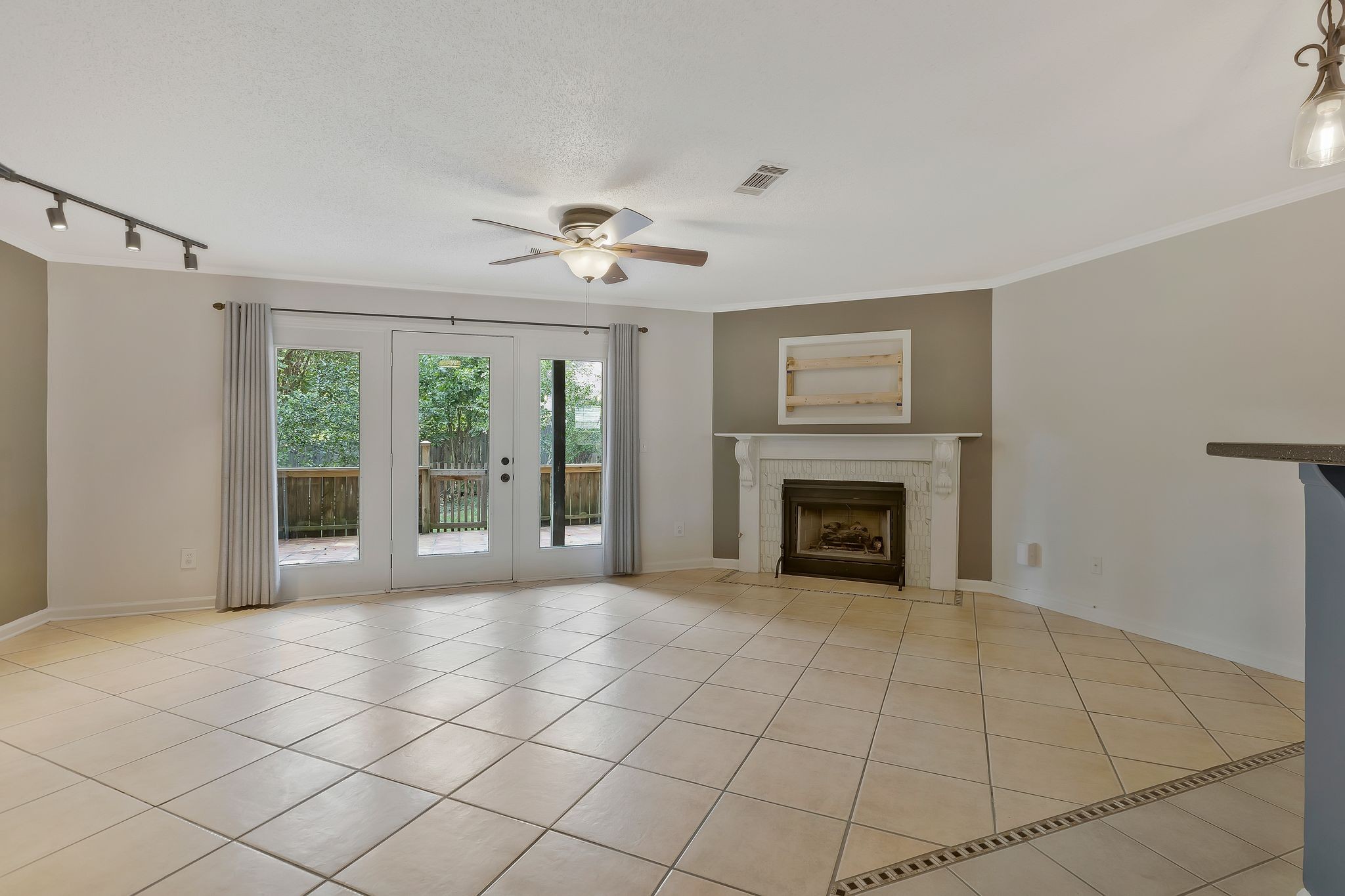 a view of an empty room with a fireplace and a window