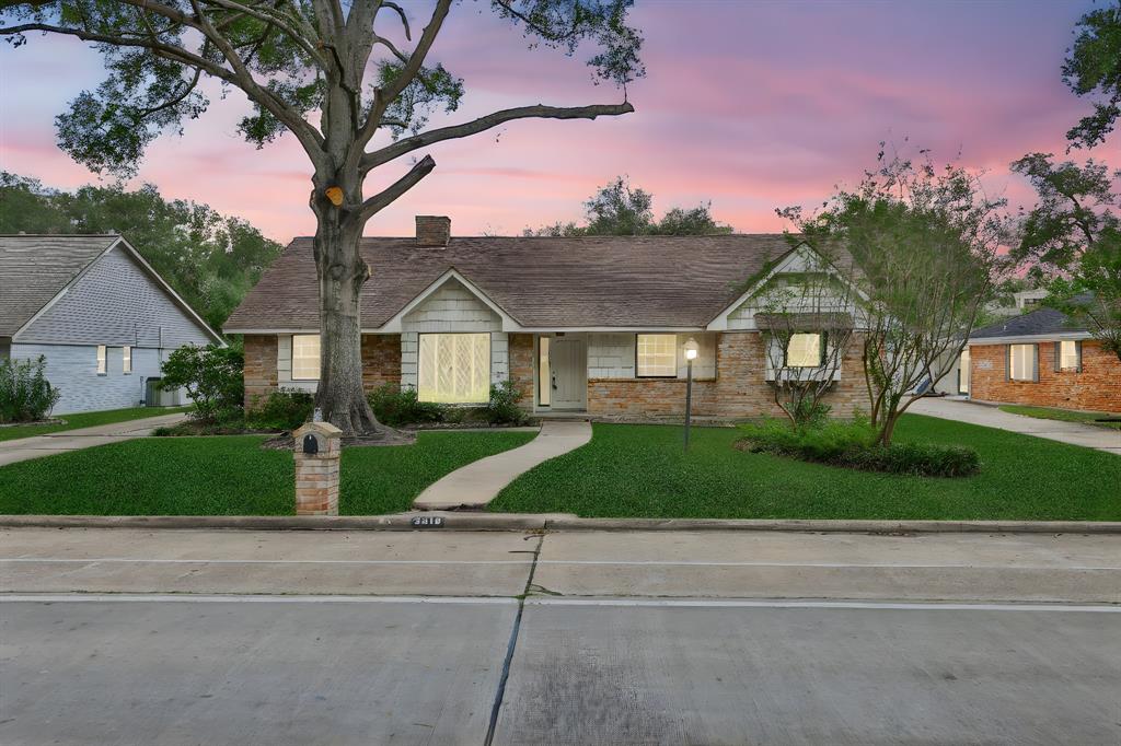 a front view of a house with a yard and trees