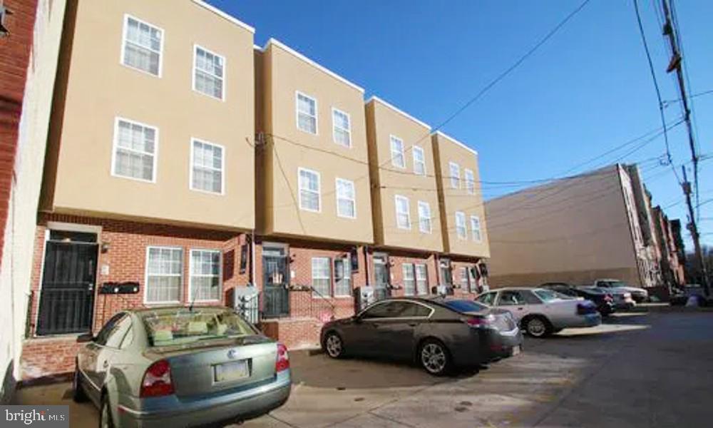 a view of a cars park in front of a building