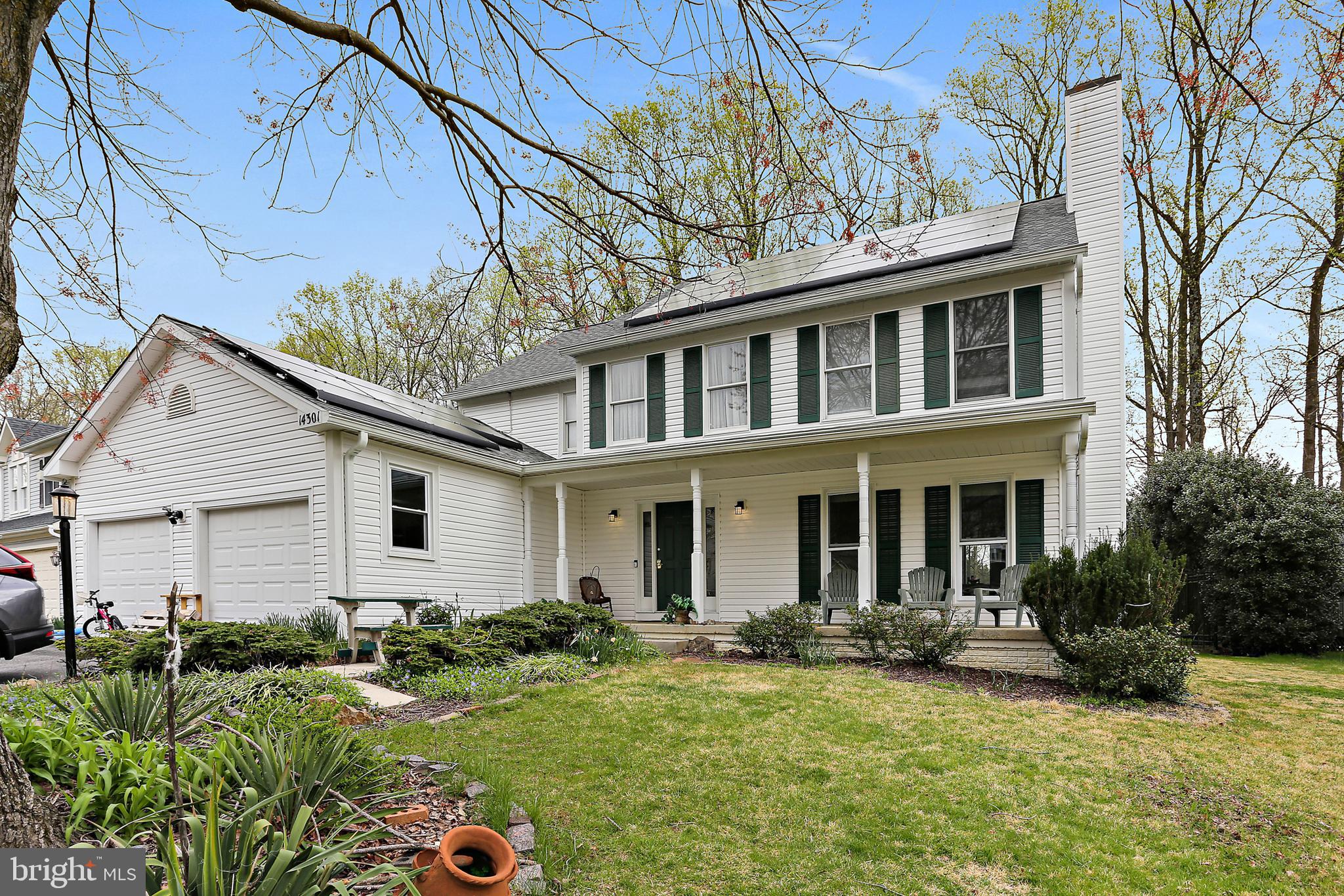 a front view of a house with yard and green space