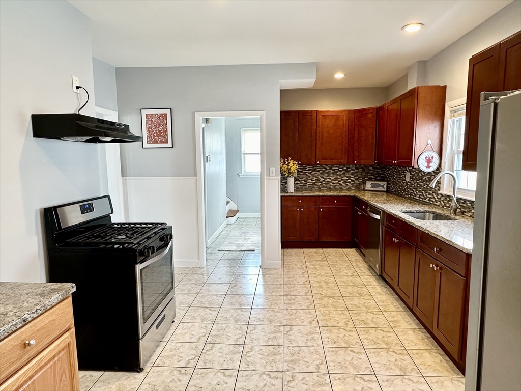 a kitchen with stainless steel appliances granite countertop a stove a refrigerator and a oven