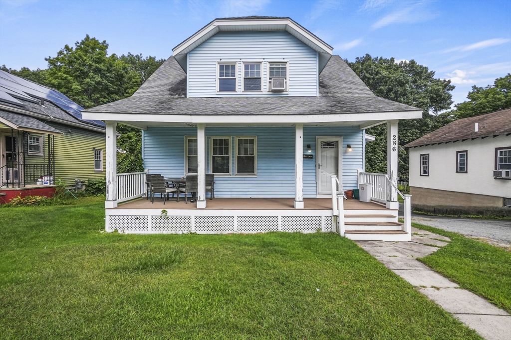 a view of a house with a yard and sitting area