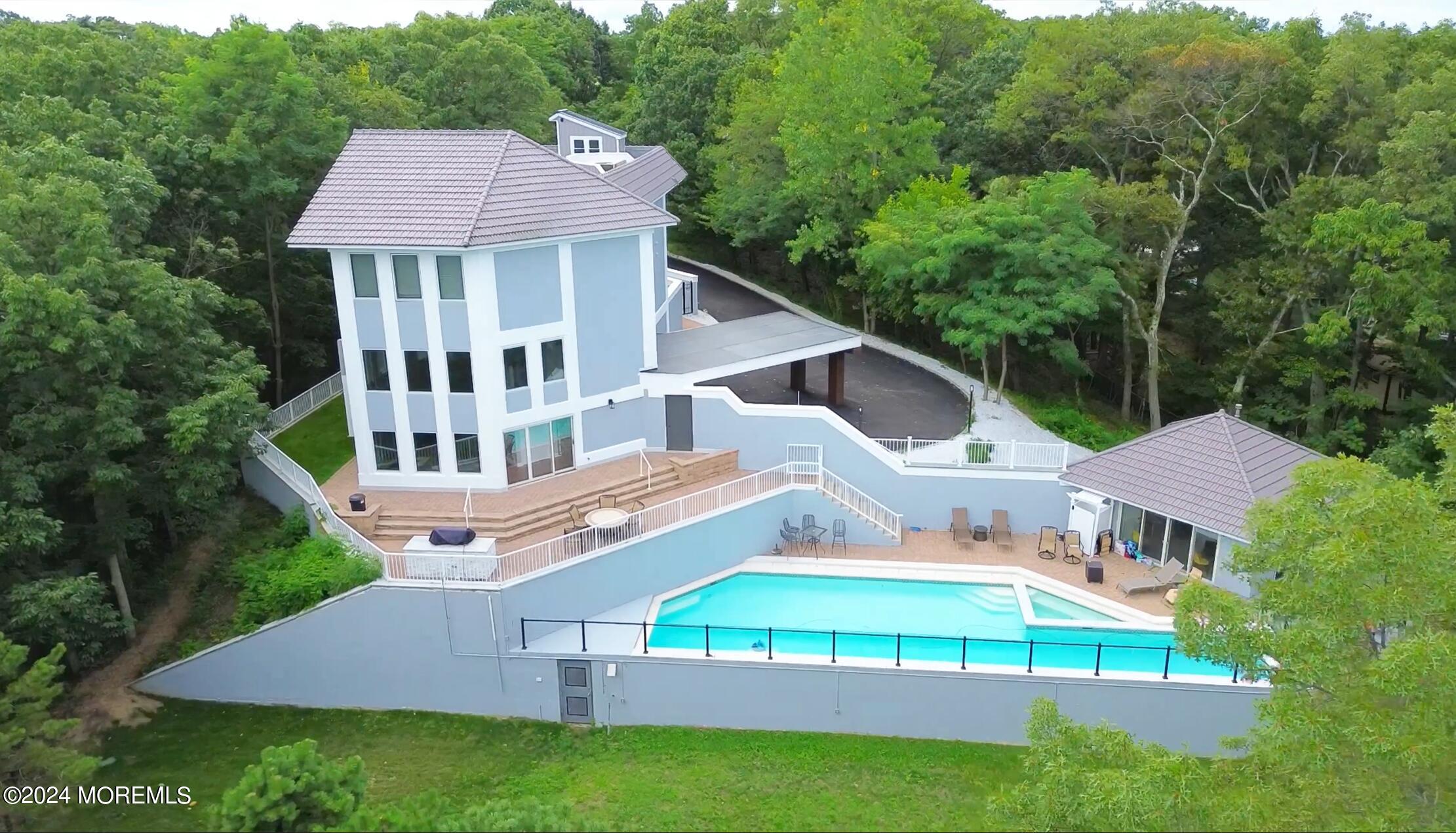 an aerial view of a house with swimming pool garden view and trees