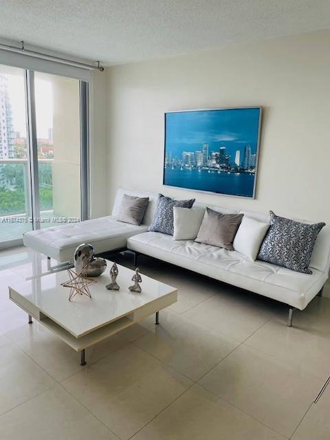 a living room with furniture and a floor to ceiling window