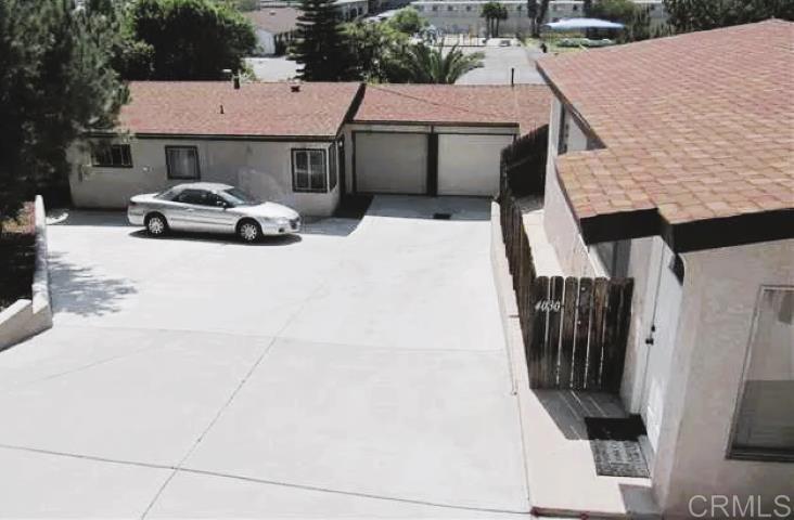 a car parked in front of house with a yard