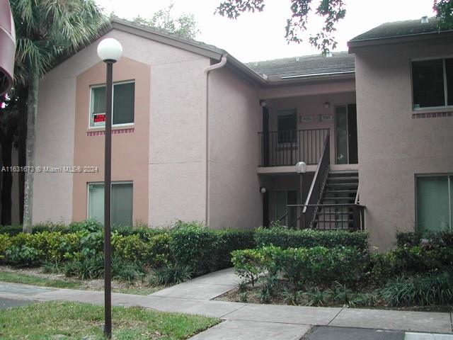 a view of a house with brick walls and plants