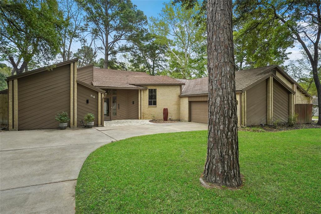 a front view of a house with a garden and trees