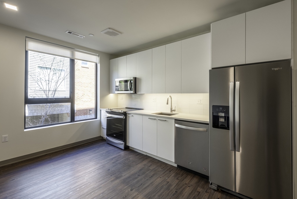 a kitchen with stainless steel appliances a refrigerator sink and cabinets