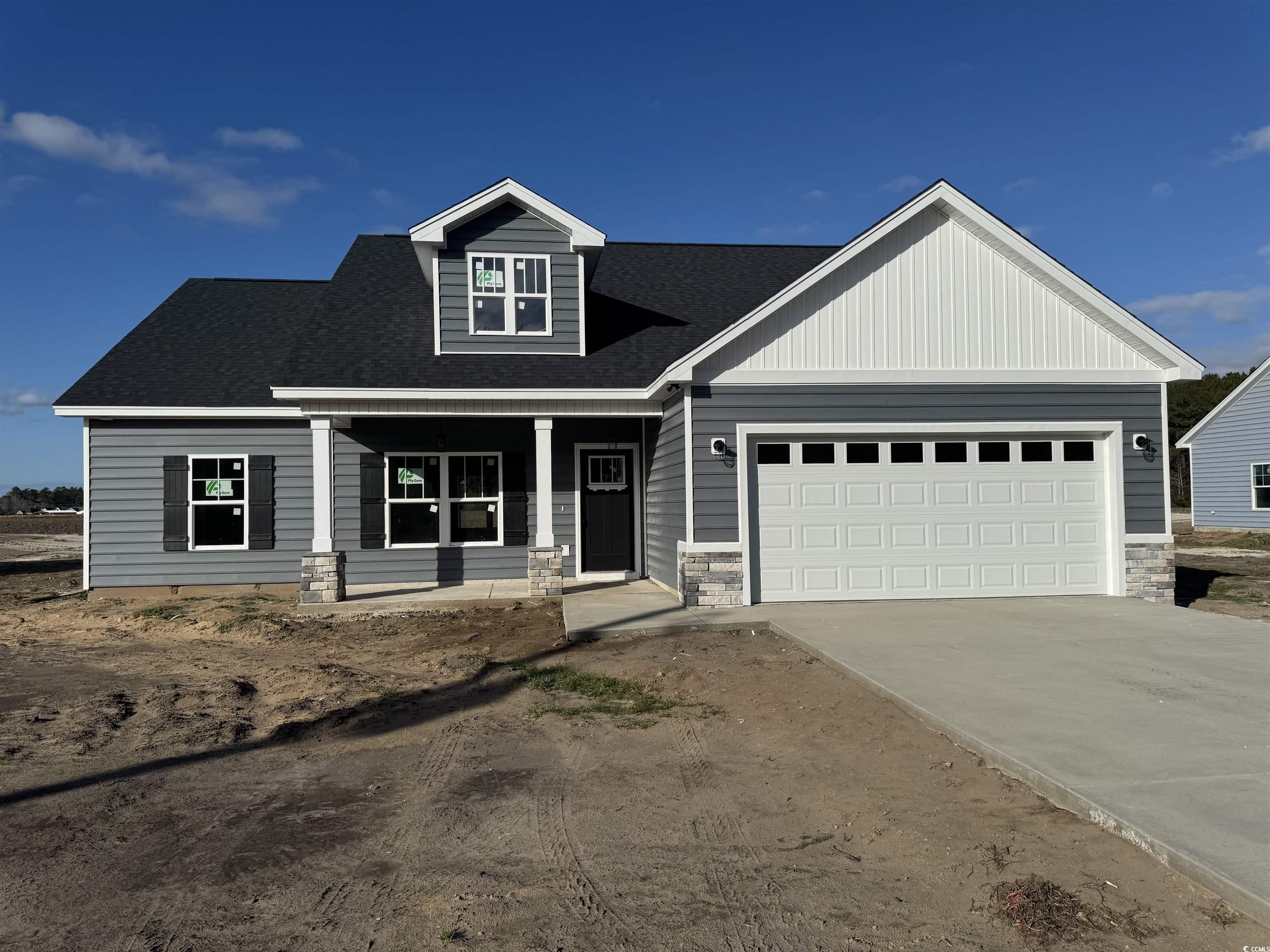 View of front of house with covered porch and a ga