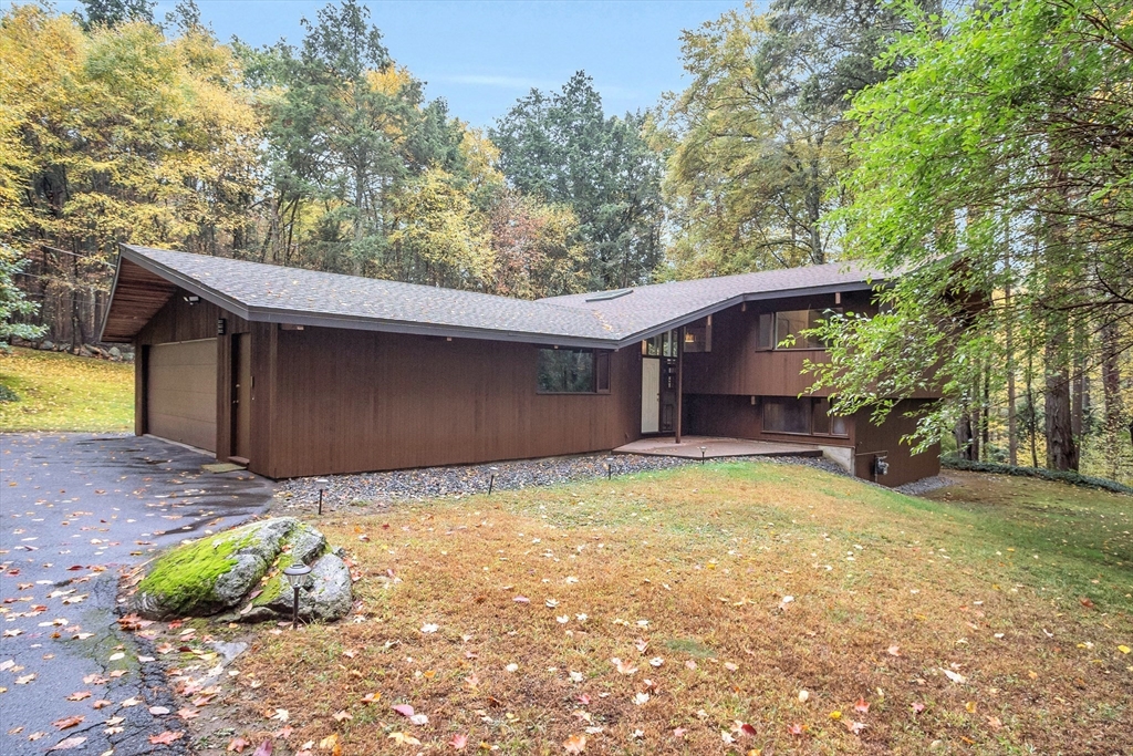 a view of a house with a yard and large tree