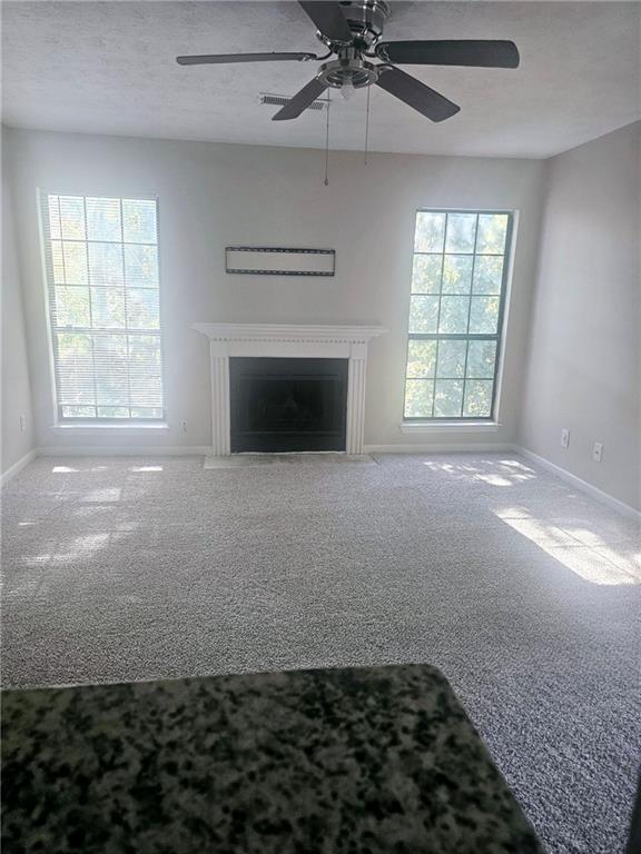 an empty room with a fireplace and windows