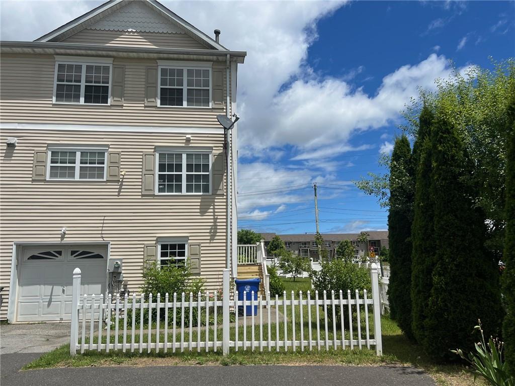 View of front of property with a garage facade and a small front yard.  Remember there isn't enough room for a car in this garage because they installed a basement bathroom that cut into the garage space. Plenty of room for storage.