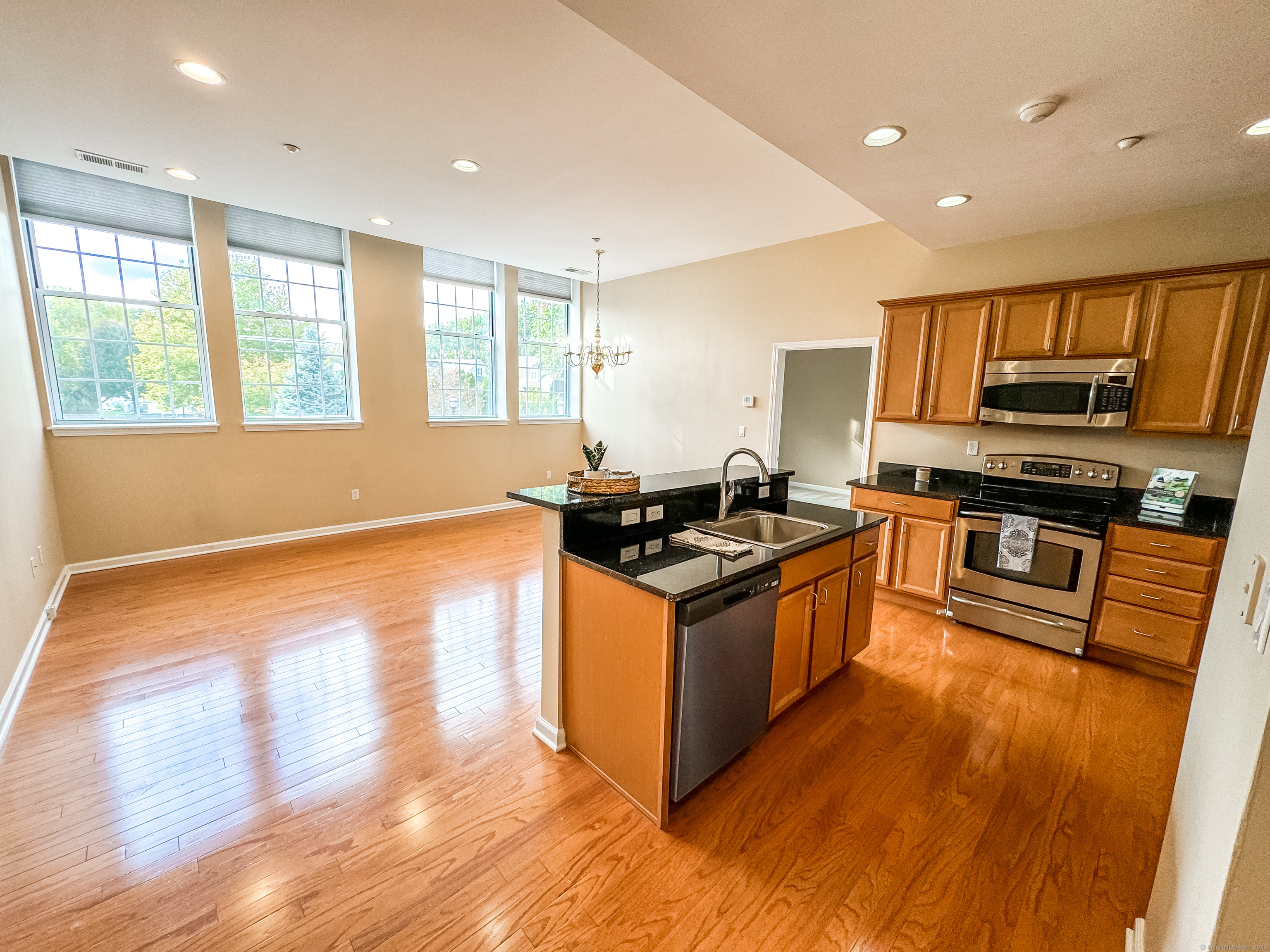 a kitchen with stainless steel appliances granite countertop a stove a sink and a refrigerator